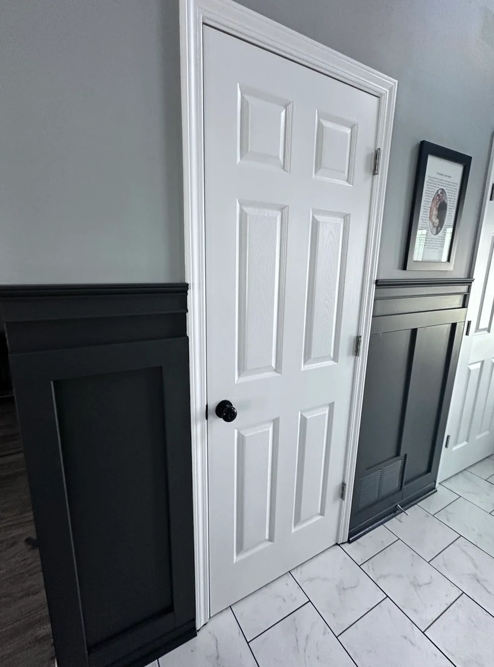 Pasillo con paneles estilo shaker en negro carbón y puertas blancas